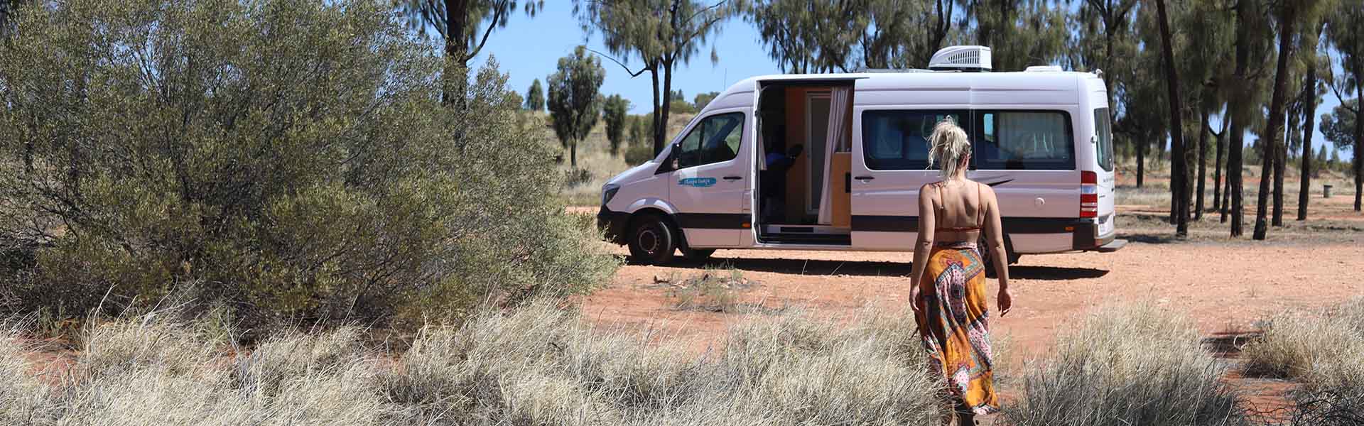 Woman walking to Cheapa 2 Berth Campervan in bush